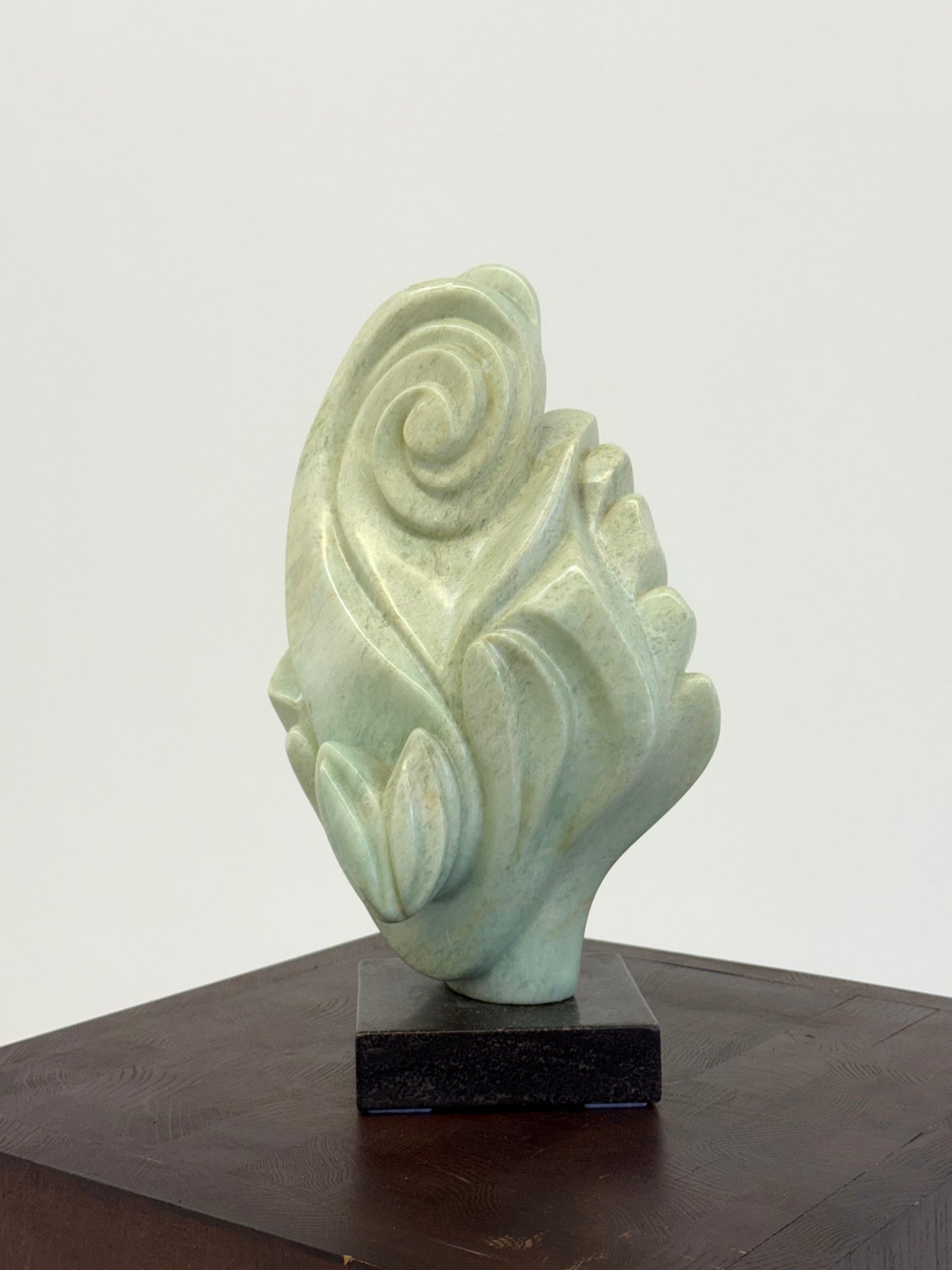 Groene natuursteen sculpture op marmeren Sokkel