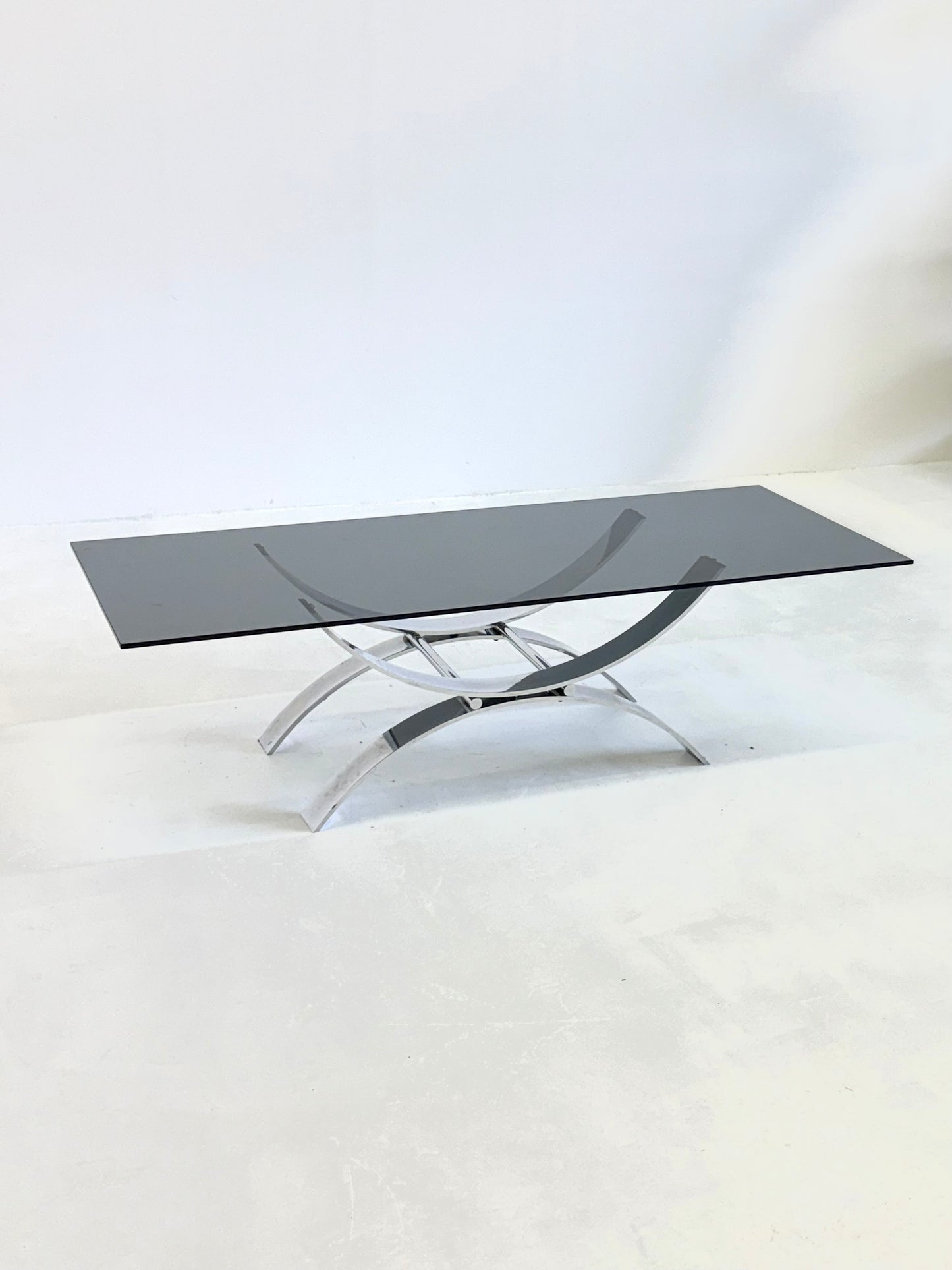 Langwerpige glazen salontafel met sierlijk chroom onderstel