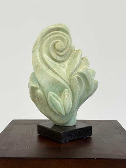 Groene natuursteen sculpture op marmeren Sokkel