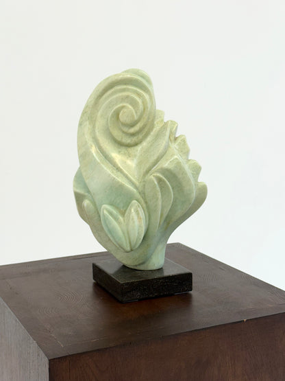 Groene natuursteen sculpture op marmeren Sokkel