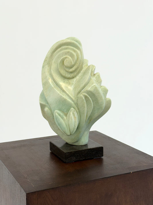 Groene natuursteen sculpture op marmeren Sokkel