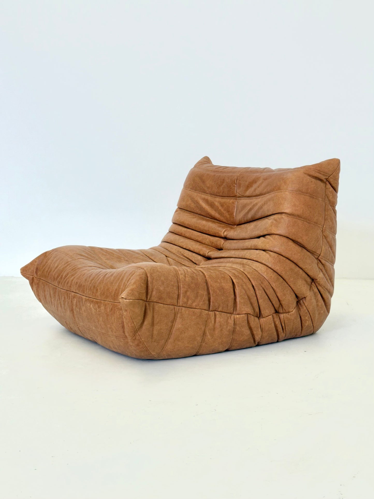 Ligne Roset Togo fauteuil met poef in cognac leer