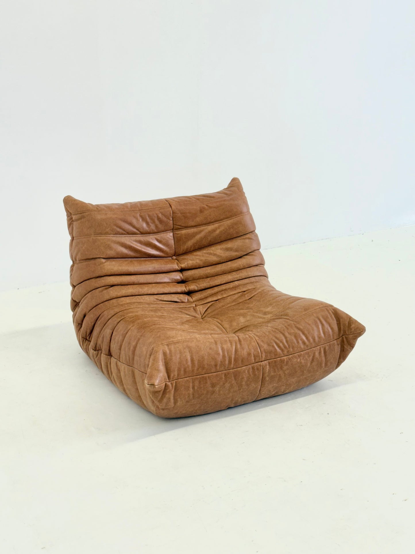 Ligne Roset Togo fauteuil met poef in cognac leer