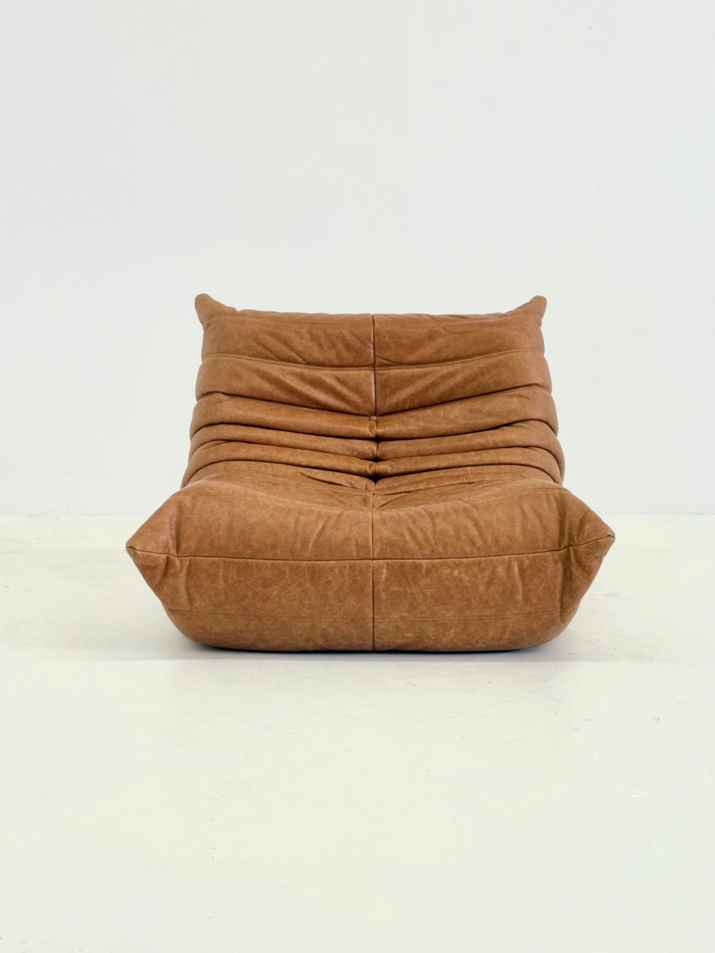 Ligne Roset Togo fauteuil met poef in cognac leer